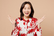 Young excited cool happy astonished woman of Asian ethnicity wear red shirt look camera spread hands say wow isolated on plain pastel light beige background studio portrait. People lifestyle concept.