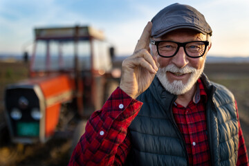 Poster - Mature farmer greeting in front of tractor