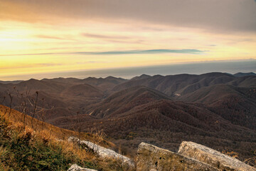 Wall Mural - View at dawn from the top of Mount Peus in the North-Western Caucasus. View from a height of 1000 m on the mountain peaks of the Black Sea coast of the Caucasus.