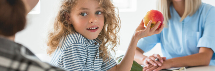 Canvas Print - Little boy playing with fruit during a visit to a dietitian