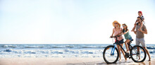 Happy Family With Bicycle On Sandy Beach Near Sea, Space For Text. Banner Design
