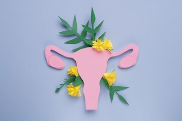 Wall Mural - Woman's health. Paper uterus and flowers on light blue background, flat lay