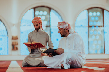 Wall Mural - A group of Muslims reading the holy book of the Quran in a modern mosque during the Muslim holiday of Ramadan