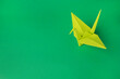 © New Africa - Paper origami crane on green background, space for text