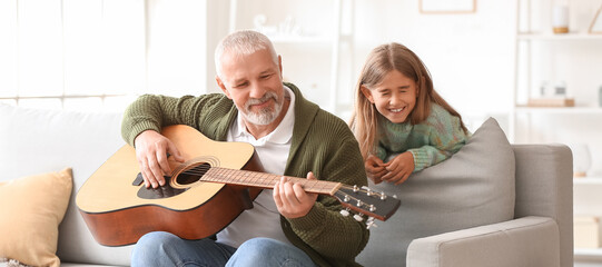 Canvas Print - Senior man with his little granddaughter playing guitar at home