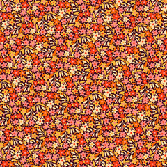 Simple floral Ditsy pattern of small wild red, orange and yellow flowers isolated on a dark brown background