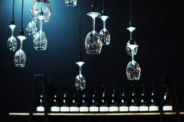 Wine glasses in the form of a small chandelier. Idea for decorating the room with glass objects and elements. An unusual solution for using wine glasses to illuminate the room. Foreground