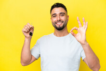 Young Arab Man Holding Home Keys Isolated On Yellow Background Showing Ok Sign With Fingers