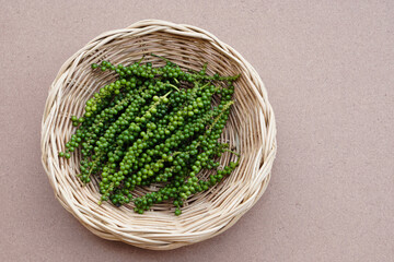  Fresh green young Thai pepper fruits in basket, isolated on brown background.Concept, herbal spices for cooking , food ingredient can be cooked in verious Thai food menu.   