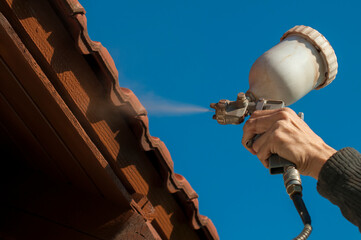 closeup of roof painting .person painting roof