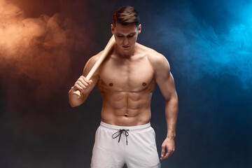 Poster - Waist up portrait view of muscle man posing in studio with baseball bat