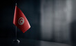 Small national flag of the Tunisia on a black background