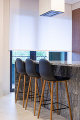 Poster - Roller blind large size on the window in the interior. Motorized roller shade white color in the kitchen. Bar counter with built-in hob and hood above it are near the window. Smart home concept. 