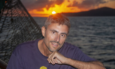 Wall Mural - Portrait of a happy caucasian man relaxing on a cruise ship at sunset