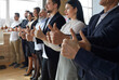 © Studio Romantic - Team of happy business people standing in office and giving thumbs up. Group of workers or business school students sharing feedback on training class, standing in row and doing like gesture together