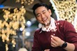 © Mallika - Smiling Asian man holding sparklers celebrating Christmas and new year party night.