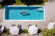 two people swim in the pool at the hotel. View from above, a couple of men and women in a swimming pool of a luxury vacation home in France Europe