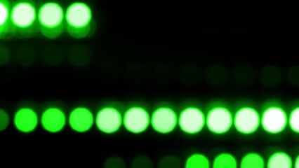Wall Mural - Lines of round green bokeh move horizontally. Abstract moving background with natural lens flare effect of blurry particles and light leaks, Can be used as background, screen or overlay. Loop 4K video