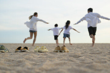 Wall Mural - Happy Asian family enjoying on beach, Family having fun together running and jumping on sandy beach, Family on beach holiday vacation, Freedom and travel concept