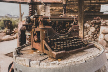 Rusty Old Type Writer Of Unknown Brand Sits On A Vintage Wooden Barrel In The Desert Sun