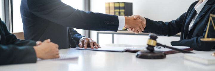 Wall Mural - Lawyer consultant shaking hand with client sign contract agreement document. in law firm. Business meeting Handshake.  