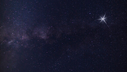 Wall Mural - glowing object in the sky next to the milky way that reminds views of a christmas star
