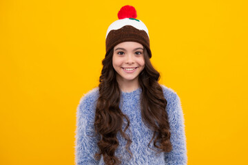 Fashion happy young woman in knitted hat and sweater having fun over colorful blue background. Happy teenager, positive and smiling emotions of teen girl.