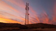 A communications tower with colorful sunset clouds