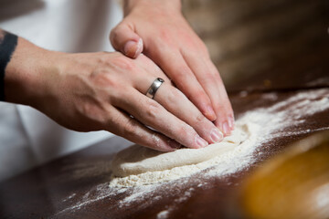 Preparing the dough for a Neapolitan pizza with tomato and cheese.