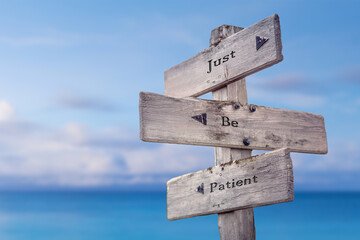 Wall Mural - just be patient text quote on wooden signpost crossroad by the sea