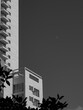 high skyscraper side with moon appearing in the sky grayscale