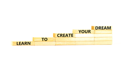 Create your dream symbol. Concept words Learn to create your dream on wooden blocks. Beautiful white table white background. Business learn to create your dream concept. Copy space.