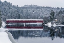 A Red Covered Bridge Over La Pêche River After A Snow Storm In Wakefield, Quebec, Canada