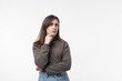 © Регина Ерофеева - portrait of pretty confident thoughtful girl,holding hand near the face, looking seriously up,standing over white background.young woman thinking worried about a question,concerned and nervous.