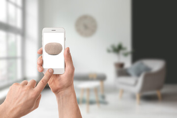 Man with mobile phone buying online new pouf in furniture store at home