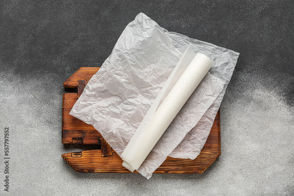 Baking paper with wooden board on black and white background