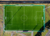 Fototapeta Morze - Aerial view. Sports soccer field seen from above. Greenery, grass, sun, empty, match