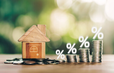 House and coins place on the wood table is ladder with white illustration shows decreasing of interest rates. planning savings money of coins to buy a home concept for property ladder, mortgage.