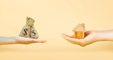 Wall Mural - Loans for real estate concept, a man and a woman hand holding a money bag and a model home put together. planning savings money of coins to buy a home concept for property mortgage. Home loan.