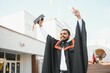 © Serhii - portrait of successful indian student in graduation gown thumb up
