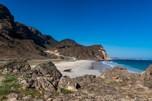 Oman, Dhofar, Salalah, Fazayah Beach With Coastal Rocks In Foreground
