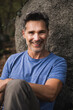 © Westend61 - Happy mature man sitting in front of rock