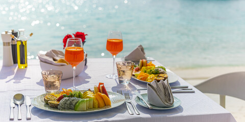 Wall Mural - Luxury sunny breakfast table beautiful tropical sea blur. Idyllic romantic morning love couples at summer holiday. Honeymoon romance togetherness vacation concept. Travel lifestyle, destination dining