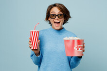 Young Excited Amazed Woman In 3d Glasses Watch Movie Film Hold In Hand Cup Of Soda Pop Cola Fizzy Water Bucket Of Popcorn In Cinema Isolated On Plain Pastel Light Blue Cyan Background Studio Portrait.