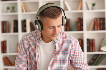 Poster - Young man with headphones studying online at home, closeup