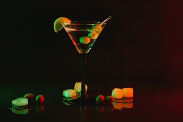 Wall Mural - Martini glass and olives on a black background with neon lights