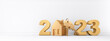 Golden symbol house and numbers 2023 against white wall - 3D illustration