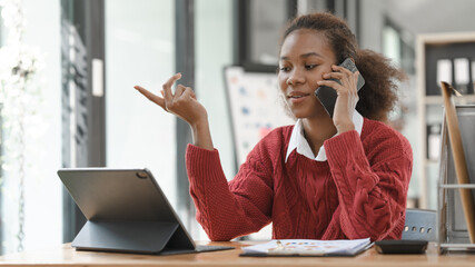 Wall Mural - Smiling African American Hispanic student looking up from laptop at campus library, using tablet and mobile