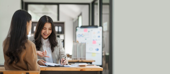 Asian company employees and colleagues work together in the office. by talking and giving advice to each other