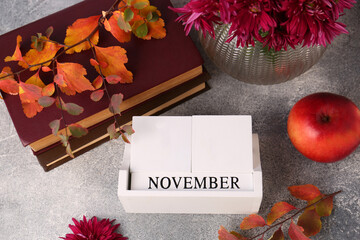 Sticker - Thanksgiving day, holiday celebrated every fourth Thursday in November. Flat lay composition with wooden block calendar and autumn leaves on grey table